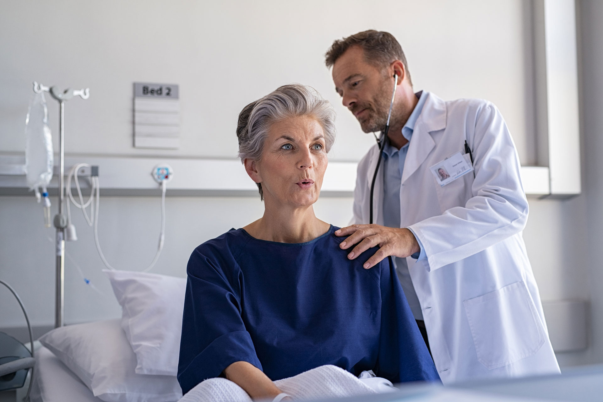 Doctor checking lungs of elder patient