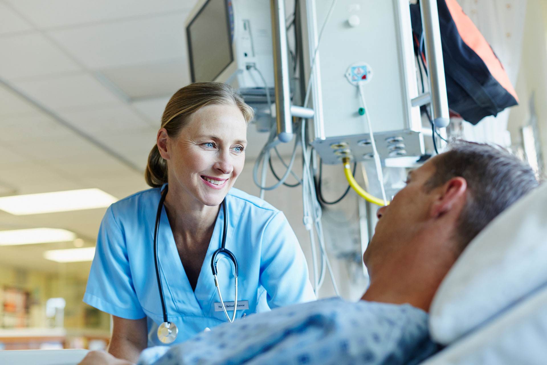 Smiling doctor looking at patient in hospital