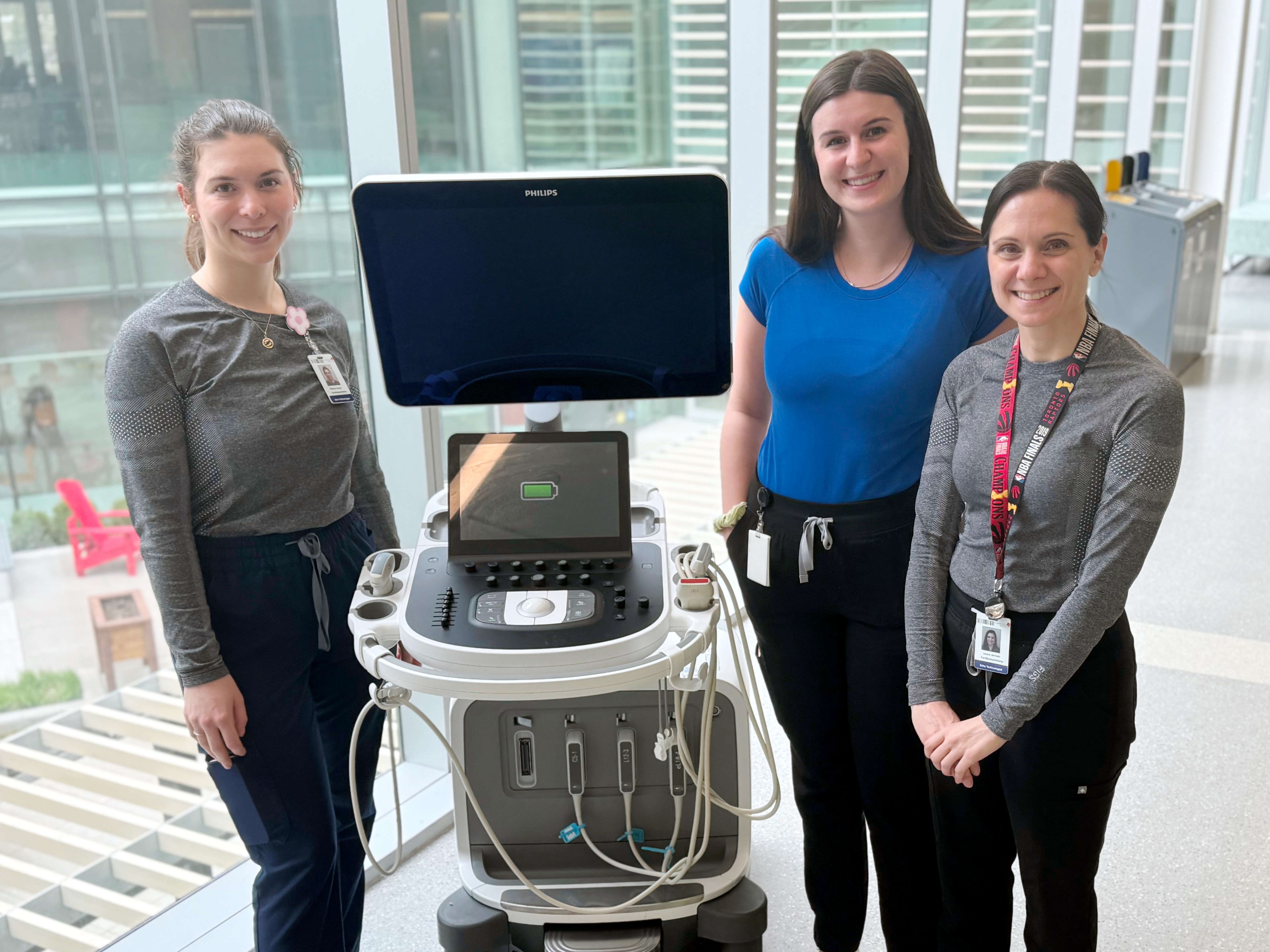 echocardiology technicians stand with an ultrasound used for echocardiograms