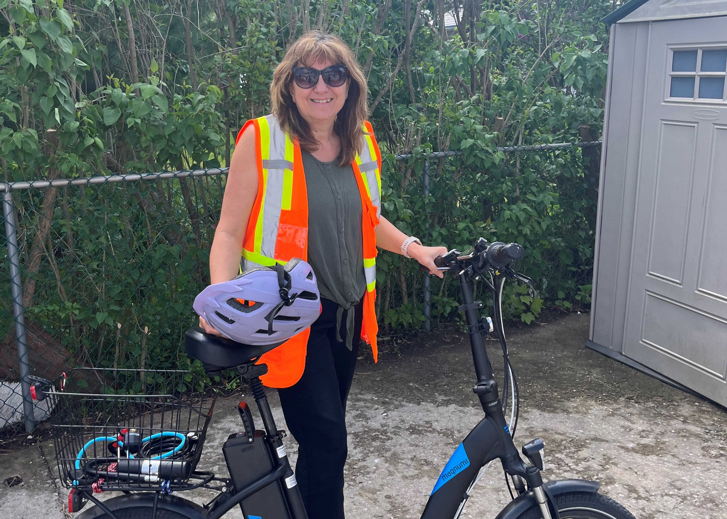 Cathy stands with her bike she rides to work every day