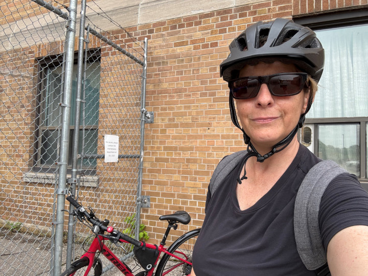 Louise stands by her bike outside the bike cage about to head home