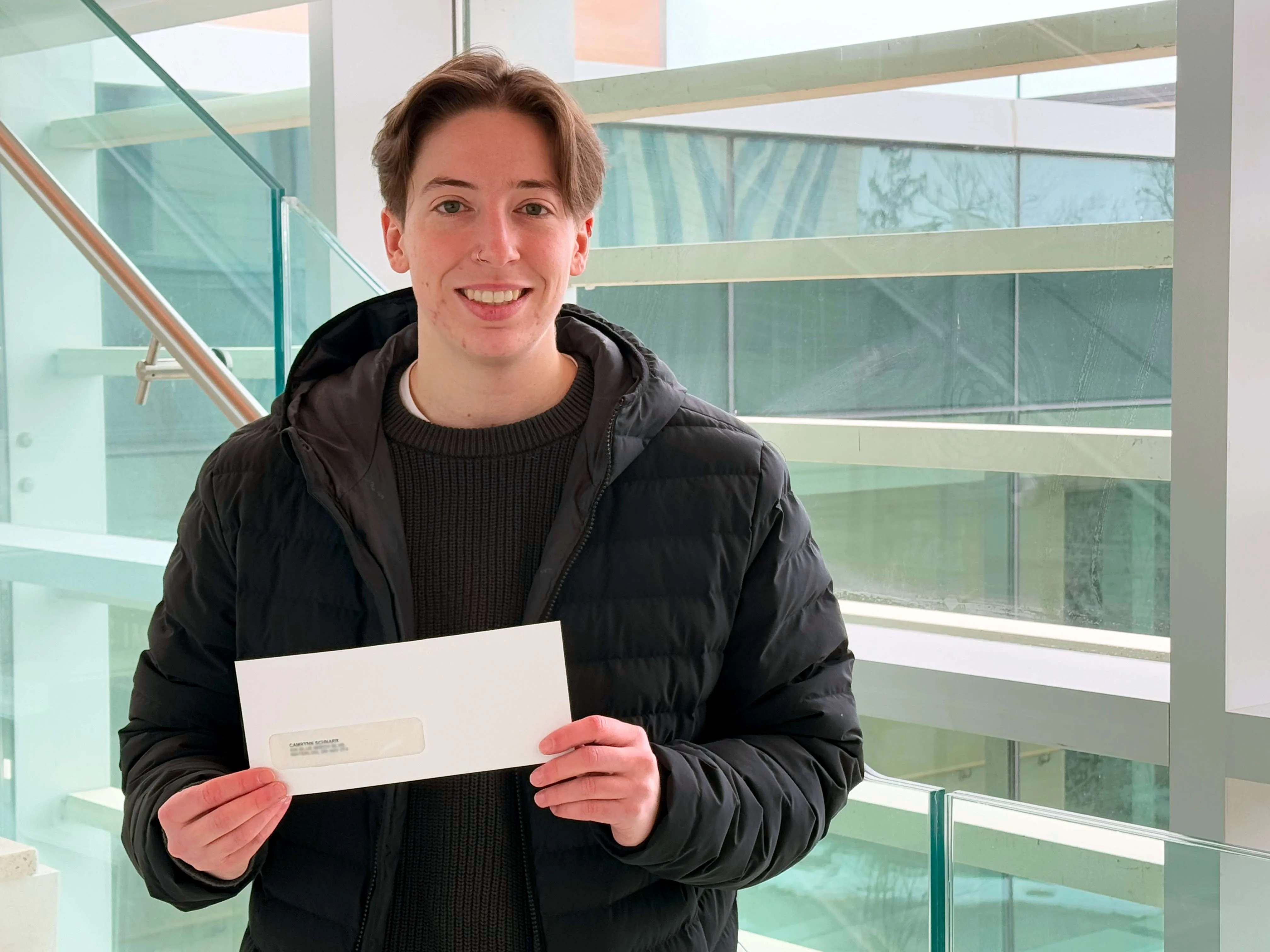 Cam holding their bursary cheque