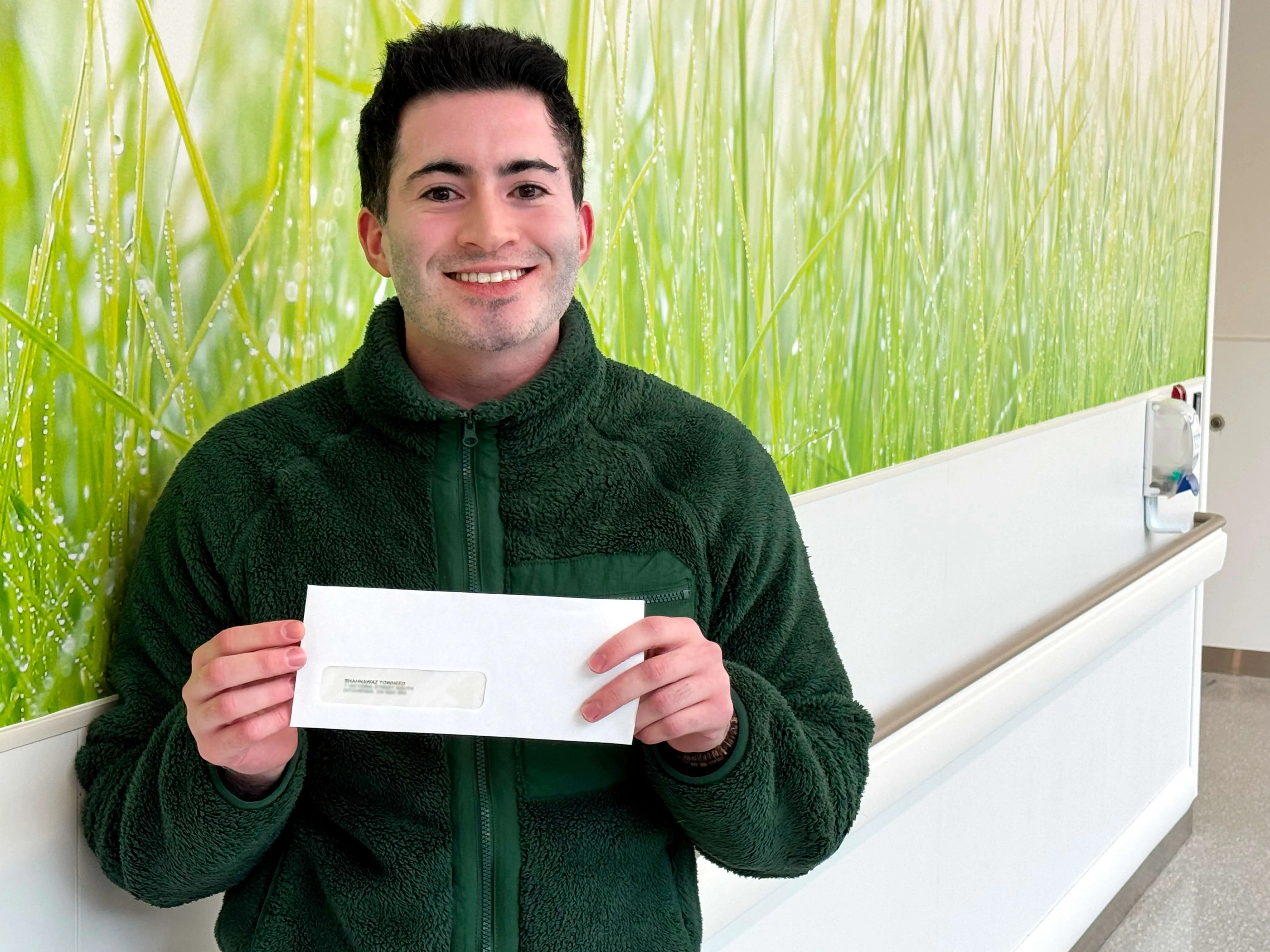 Shahnawaz holding his bursary cheque